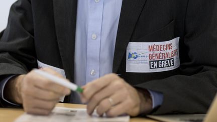 Un m&eacute;decin en gr&egrave;ve lors d'une conf&eacute;rence de presse, le 23 d&eacute;cembre 2014 &agrave; Paris.&nbsp; (KENZO TRIBOUILLARD / AFP)