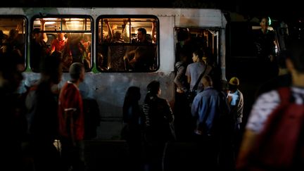 Des habitants de Caracas montent dans un bus en pleine panne de courant, le 7 mars. (STRINGER / REUTERS)