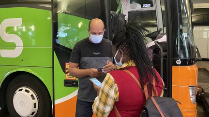 Un conducteur Flixbus vérifie le pass sanitaire d'une voyageuse, le 9 août 2021, à la gare routière de Bercy, à Paris.&nbsp; (RACHEL RODRIGUES / FRANCEINFO)