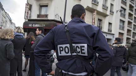 Un policier devant des restaurants et des cafés visés par des attaques, trois jours après l'assaut des terroristes, le 16 novembre, à Paris. (ETIENNE LAURENT / EPA / MAXPPP)