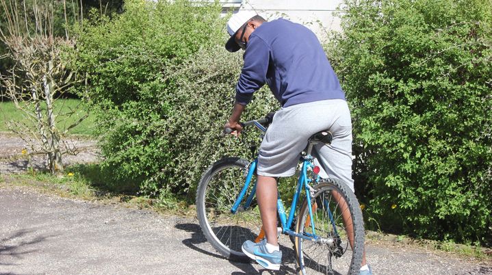 Salah Ibrahim sur son v&eacute;lo devant le centre d'accueil temporaire Adoma de Pouilly-en-Auxois, mercredi 22 avril. (CLEMENT PARROT / FRANCETV INFO)