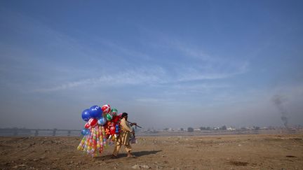 Un vendeur de ballons marche sur les berges de la rivi&egrave;re Ravi &agrave; Lahore (Pakistan), le 14 novembre 2011. (MOHSIN RAZA / REUTERS)