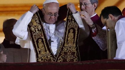 Le pape Fran&ccedil;ois enfile son &eacute;tole pastorale avant de proc&eacute;der &agrave; la b&eacute;n&eacute;diction, place Saint-Pierre (Vatican), le 13 mars 2013.&nbsp; (TONY GENTILE / REUTERS  )