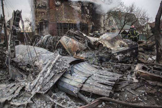 Un pompier ukrainien marche entre des fragments d'un avion abattu à Kiev, en Ukraine, le 25 février 2022. (OLEKSANDR RATUSHNIAK /AP / SIPA)