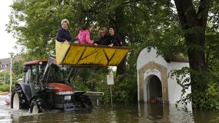 Des habitants victimes des inondations sont &eacute;vacu&eacute;s par un tractopelle &agrave;&nbsp;Niederalteich (Allemagne), le 6 juin 2013. (WOLFGANG RATTAY / REUTERS)