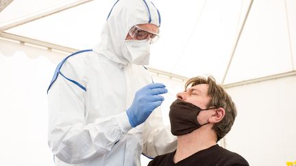 Un médecin biologiste pratique un test de dépistage du Covid-19 dans un "drive" à Montauban (Tarn-et-Garonne), le 15 juin 2020. (PATRICIA HUCHOT-BOISSIER / HANS LUCAS / AFP)