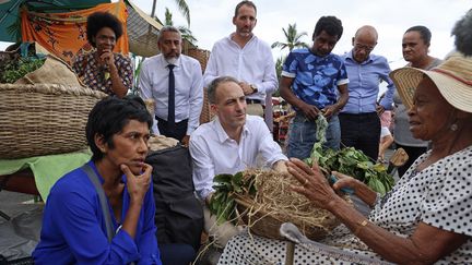 Raphaël Glucksmann (au centre) et la maire de Saint-Denis Ericka Bareigts (à gauche), écoutent une femme, sur l'île de La Réunion le 19 avril 2024. (RICHARD BOUHET / AFP)