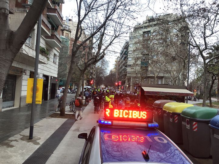 Le cortège de cyclistes est escorté par une voiture de police afin de rendre le trajet sûr, vendredi 21 janvier 2022 à Barcelone, en Espagne. (HENRY DELAGUERIE / RADIO FRANCE)