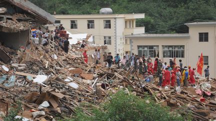 Les secours fouillent les d&eacute;combres &agrave;&nbsp;Zhaotong en Chine, le 5 ao&ucirc;t 2014, quatre jours apr&egrave;s le s&eacute;isme qui a frapp&eacute; la province du Yunann.&nbsp; (MITSURU TAMURA / YOMIURI / AFP)