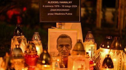 Les partisans d'Alexeï Navalny tiennent des banderoles et placent des bougies autour d'un mémorial de fortune devant le consulat russe à Cracovie, en Pologne, le 25 février 2024. (OMAR MARQUES / ANADOLU / AFP)