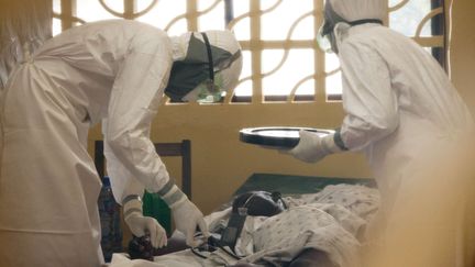 Le docteur Kent Brantly, ici &agrave; gauche, traite un patient contamin&eacute; par le virus Ebola &agrave; Monrovia (Liberia), en 2014. (SIPA / AP)