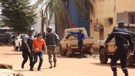 Un soldat aide un otage qui quitte la scène devant l'hôtel Radisson Blu à Bamako (Mali), le 20 novembre 2015. (HAROUNA TRAORE / AP / SIPA)