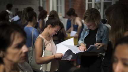 Des lyc&eacute;ens consultent leurs r&eacute;sultats du baccalaur&eacute;at le 7 juillet 2015 au lyc&eacute;e Georges-Brassens &agrave; Paris. (MARTIN BUREAU / AFP)