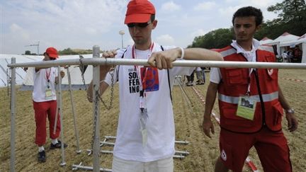 de jeunes volontaires de la Croix-Rouge préparent une réserve d'eau, à Solferino (Italie), le 26/06/09 (© AFP/Damien Meyer)