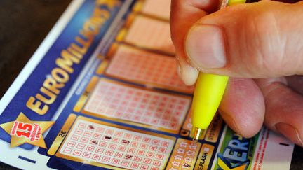 Un joueur remplit une grille d'Euro Millions &agrave; Lille (Nord), le 7 ao&ucirc;t 2012. (PHILIPPE HUGUEN / AFP)