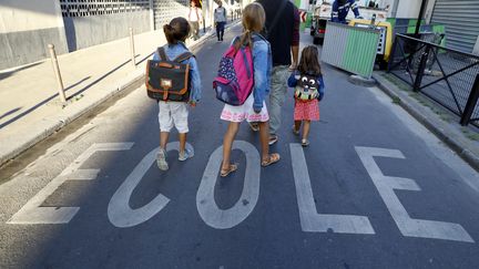 Des enfants sur le chemin de l'école, à Paris, le 1er septembre 2016.&nbsp; (PATRICK KOVARIK / AFP)