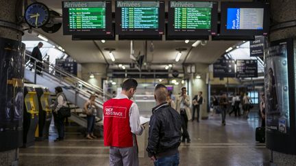 Un employer de la SNCF renseigne un voyagueur à la gare de Lyon Part Dieu en juin 2014. (Illustration) (JEFF PACHOUD / AFP)