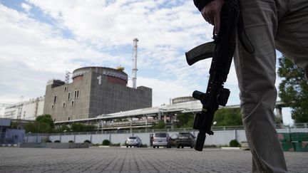 Un officier de la sécurité se tient devant la centrale nucléaire de Zaporijjia (Ukraine), le 11 septembre 2022.&nbsp; (STRINGER / AFP)