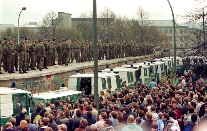 Des centaines de Berlinois de l'Est face aux "Vopos" déployés sur le Mur, le 11 novembre 1989, près de la porte de Brandebourg. (REUTERS)