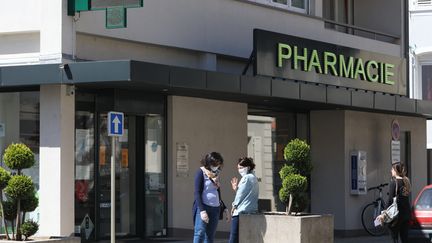 Des femmes avec un masque devant une pharmacie à Mulhouse dans le Haut-Rhin, le 27 avril.&nbsp; (VINCENT VOEGTLIN / MAXPPP)