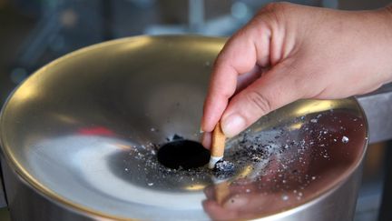 Une cigarette écrasée dans un cendrier. (PATRIK STOLLARZ / AFP)