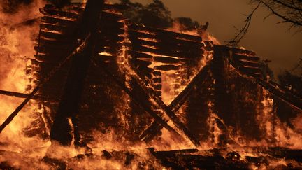 Een brandend huis in Varnavas, ten noorden van Athene, 11 augustus 2024. (ANGELOS TZORTZINIS / AFP)