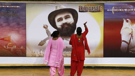 Deux femmes adeptes du gourou indien&nbsp;Gurmeet Ram Rahim Singh, devant l'affiche de son nouveau film, le 5 octobre 2016 à New Delhi (Inde).&nbsp; (TSERING TOPGYAL / SIPA)