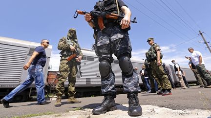 &nbsp; (Les rebelles gardent le train réfrigéré qui transporte les corps des victimes du crash, pendant que les experts de l'OSCE attendent l'ouverture du train. © MaxPPP / Robert Ghement)