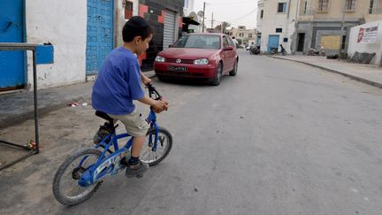 Un enfant sur son vélo, en Tunisie. (FETHI BELAID / AFP)