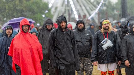 Le ciel leur est tombé sur la tête mais ces courageux festivaliers sont restés écouter Thundermother, dimanche 18 juin 2023 au Hellfest. (MATHIEU PATTIER / OUEST FRANCE / MAXPPP)