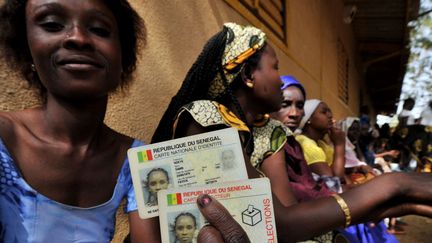 Une Sénégalaise montre sa carte d'identité et sa carte d'électeur. (ISSOUF SANOGO / AFP)