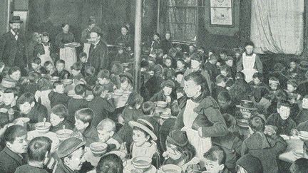 Un repas gratuit servi à des enfants de familles pauvres à Londres vers 1910. C'est dans ces milieux qu'étaient choisis les enfants désignés pour partir outre-mer. (AFP - ANN RONAN PICTURE LIBRARY - PHOTO12)