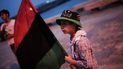 Un enfant libyen tenant une drapeau libyen sur une plage, à Benghazi, le 2 juin 2011 (AFP/Gianluigi GUERCIA)