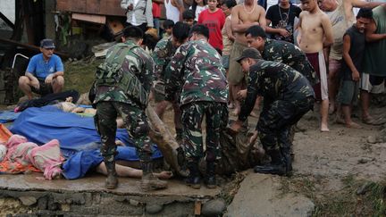 Des soldats philippins &eacute;vacuent des corps &agrave; Iligan City, le 17 d&eacute;cembre 2011. (CHERRYL VERGEIRE / AFP PHOTO)