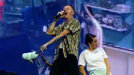 MACKLEMORE, Samedi à 21h30 - La voilà la star de ce Main Square 2019. L'homme que 10.000 personnes sont venues attendre devant la scène principale plusieurs heures avant le début de son concert. Le rappeur Macklemore, sans son camarade Ryan Lewis, a livré un show de haute volée, calibré et millimétré sans perdre en énergie communicative. Alignant les tubes puissants et positifs, Macklemore a conquis sans peine un public déjà acquis à sa cause. Durant le live de Martin Garrix, quelques temps après la fin de sa prestation, Macklemore est même revenu faire une courte apparition le temps d'un morceau.&nbsp; (LUDOVIC MAILLARD / MAXPPP)