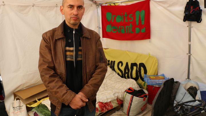 Ibrahim Aly devant son matelas et ses affaires, dans le campement de l&rsquo;association Droit au logement, place de la R&eacute;publique, &agrave; Paris. (VALENTINE PASQUESOONE/ L'ANGLE ÉCO)