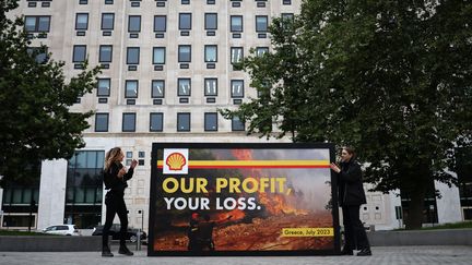 Des activistes de Greenpeace devant le siège de Shell à Londres (Royaume-Uni), le 27 juillet 2023. (HENRY NICHOLLS / AFP)