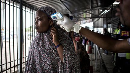 Une femme se fait prendre la température dans un centre médical consacré à Ebola, le 16 juillet 2019, à Goma (République démocratique du Congo).&nbsp; (JOHN WESSELS / AFP)