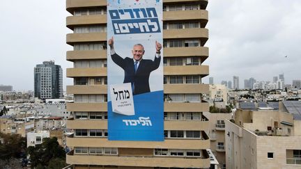 Une affiche de campagne de Benyamin Netanyahou, avec le slogan "Retour à la vie", sur la façade d'un immeuble de Tel Aviv, le 11 mars 2021. (JACK GUEZ / AFP)