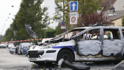 Une voiture de police incendiée à&nbsp;Viry-Chatillon, le 8 octobre 2016, jour de l'agression de quatre policiers dans cette commune de l'Essonne.&nbsp; (THOMAS SAMSON / AFP)