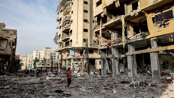 Des Palestiniens marchent au milieu des décombres après des frappes israéliennes sur la ville de Gaza, le 11 octobre 2023. (MOHAMMED ABED / AFP)