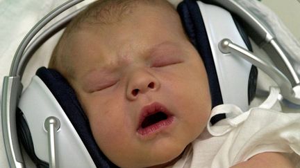 Un b&eacute;b&eacute; &eacute;coute de la musique dans une maternit&eacute; de Bratislava (Slovaquie), le 6 ao&ucirc;t 2004. (MAXPPP)