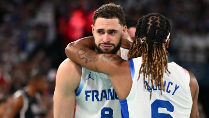 Isaïa Cordinier et Andrew Albicy, déçus, après la défaite de la France contre les Etats-Unis en finale des Jeux olympiques de Paris, le 10 août 2024 à l'Arena Bercy. (AFP)