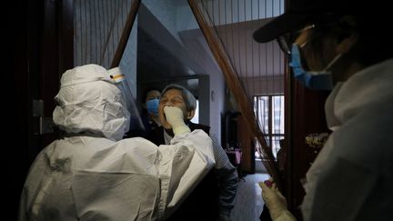 Une habitante de Wuhan (Chine), épicentre de l'épidémie, se soumet à un test de dépistage du Covid-19, le 14 mai 2020. (STR / AFP)