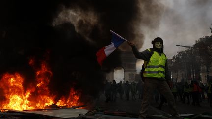 Un manifestant lors de la mobilisation des "gilets jaunes" près de l'Arc de triomphe à Paris, le 24 novembre 2018. (MEHDI TAAMALLAH / NURPHOTO / AFP)