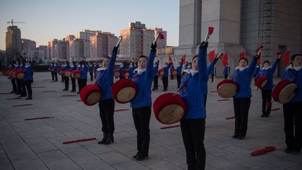 Tout au long de la campagne de propagande, des dizaines de femmes armées de tambours et de drapeaux rouges, étaient positionnées à des endroits stratégiques de Pyongyang pour motiver les Nords-Coréens à travailler plus. Mais pour de nombreux experts étrangers, cette mobilisation de masse a un impact négatif sur la productivité car contribuant à une fatigue généralisée des travailleurs.   ( KIM WON-JIN / AFP - Décembre 2016)