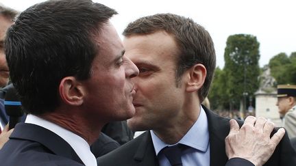 Manuel Valls et Emmanuel Macron lors du défilé du 14 juillet 2016 à Paris. (THIBAULT CAMUS / POOL / AP POOL)