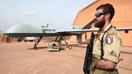 Un militaire français de l'opération Barkane se tient à côté d'un drone Reaper, le 14 mars 2016, à Niamey (Niger).&nbsp; (PASCAL GUYOT / AFP)