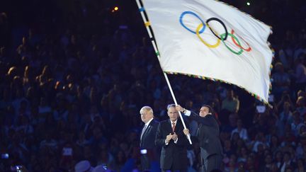 Le maire de Rio de Janeiro Eduardo Paes, o&ugrave; seront organis&eacute;s les Jeux de 2016, a re&ccedil;u le drapeau olympique des mains de Jacques Rogge, pr&eacute;sident du CIO, sous le regard du maire de Londres Boris Johnson. (ODD ANDERSEN / AFP)