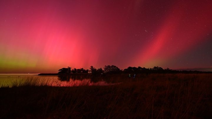 Les aurores australes, visibles depuis le lac d'Ellesmere, près de Christchurch, en Nouvelle-Zélande, le 11 mai 2024. (SANKA VIDANAGAMA / AFP)